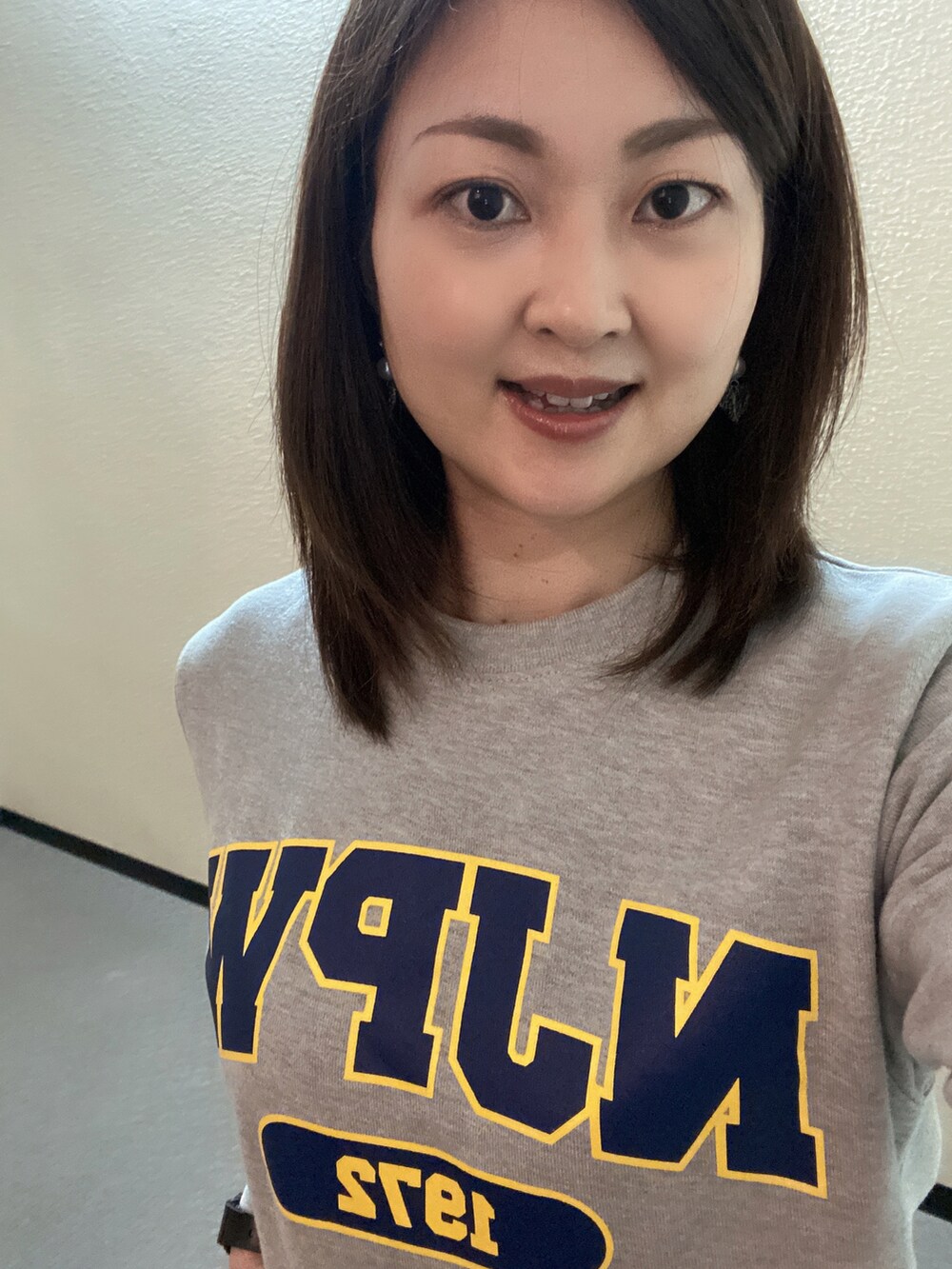 ブラック系のスカート、グレー系のスウェット、ブラック系のスニーカーを着用したレディースの春コーディネートの3枚目の写真