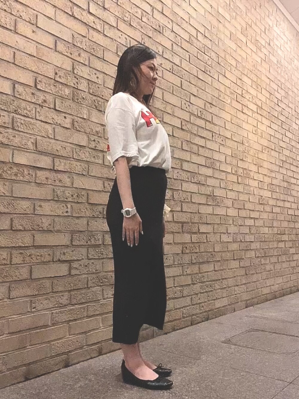 ホワイト系のTシャツ/カットソー、ブラック系のスカート、ブラック系のレインシューズを着用したレディースの夏コーディネートの2枚目の写真