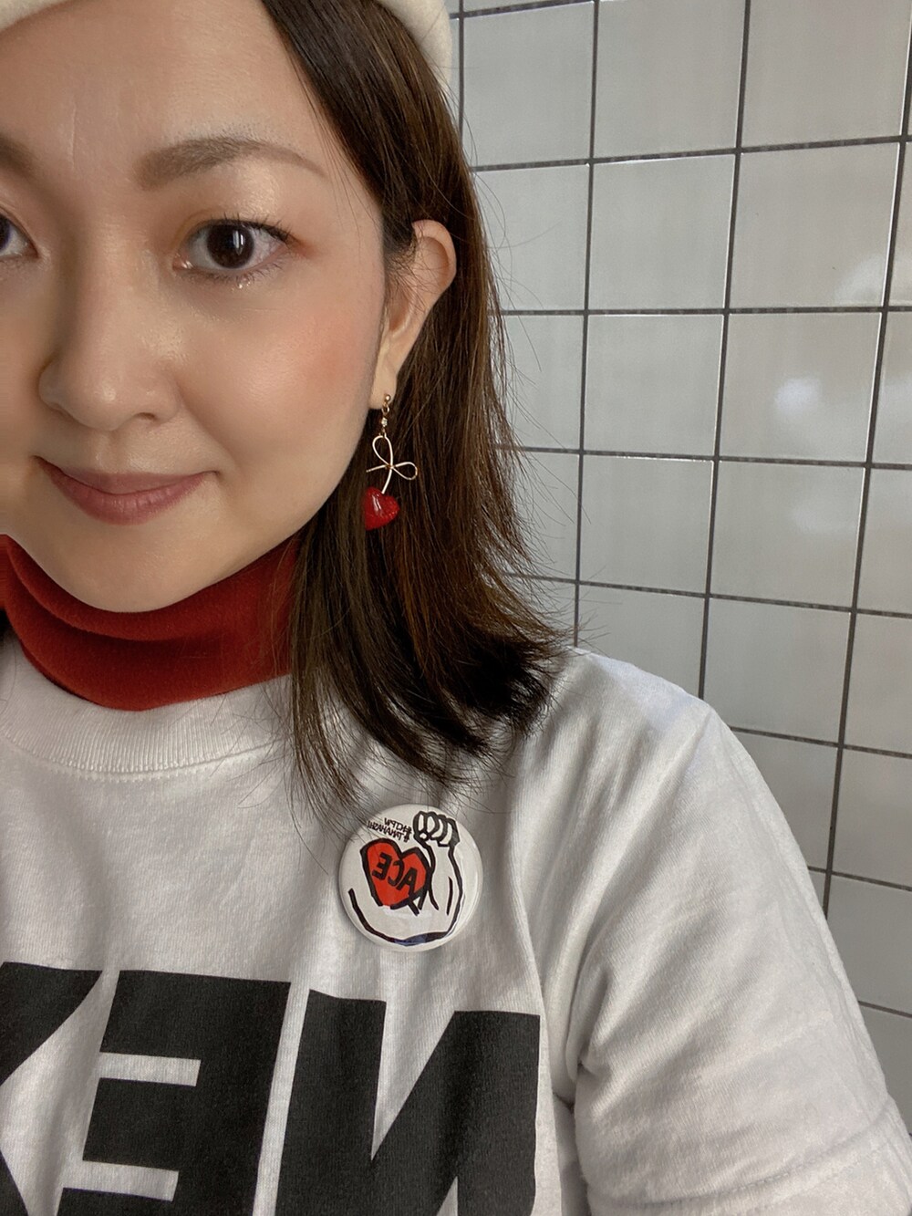 ホワイト系のTシャツ/カットソー、レッド系のその他トップス、ホワイト系のライダースジャケットを着用したレディースの冬コーディネートの3枚目の写真