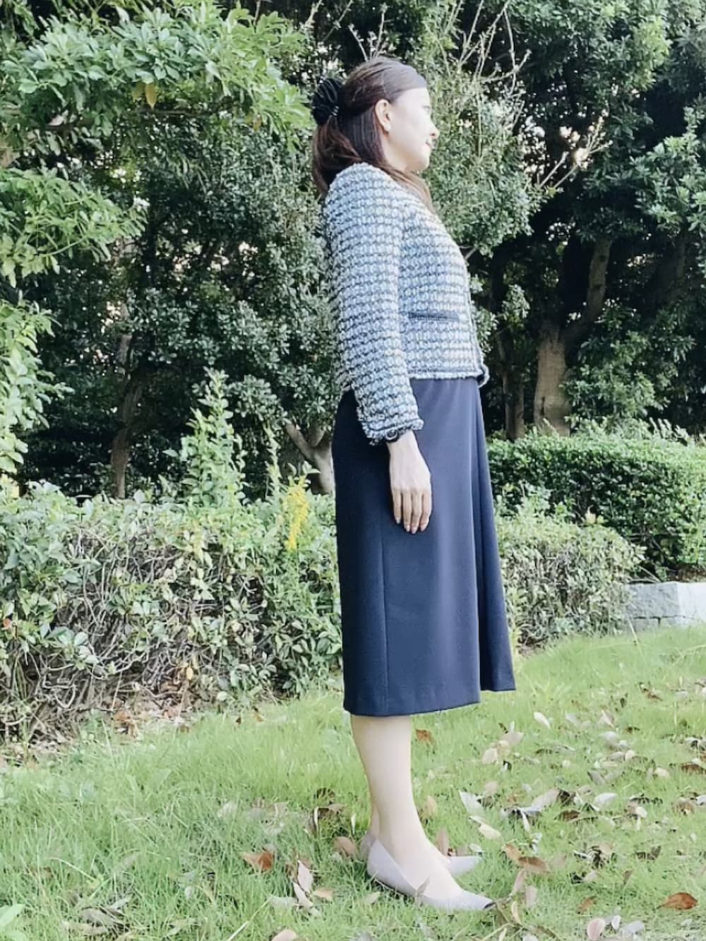 ブルー系のスーツセット、ベージュ系のパンプス、ホワイト系のネックレスを着用したレディースの秋コーディネートの2枚目の写真