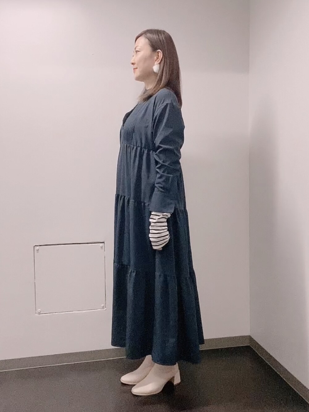 ブルー系のワンピース、ホワイト系のTシャツ/カットソー、ホワイト系のブーツを着用したレディースの冬コーディネートの4枚目の写真