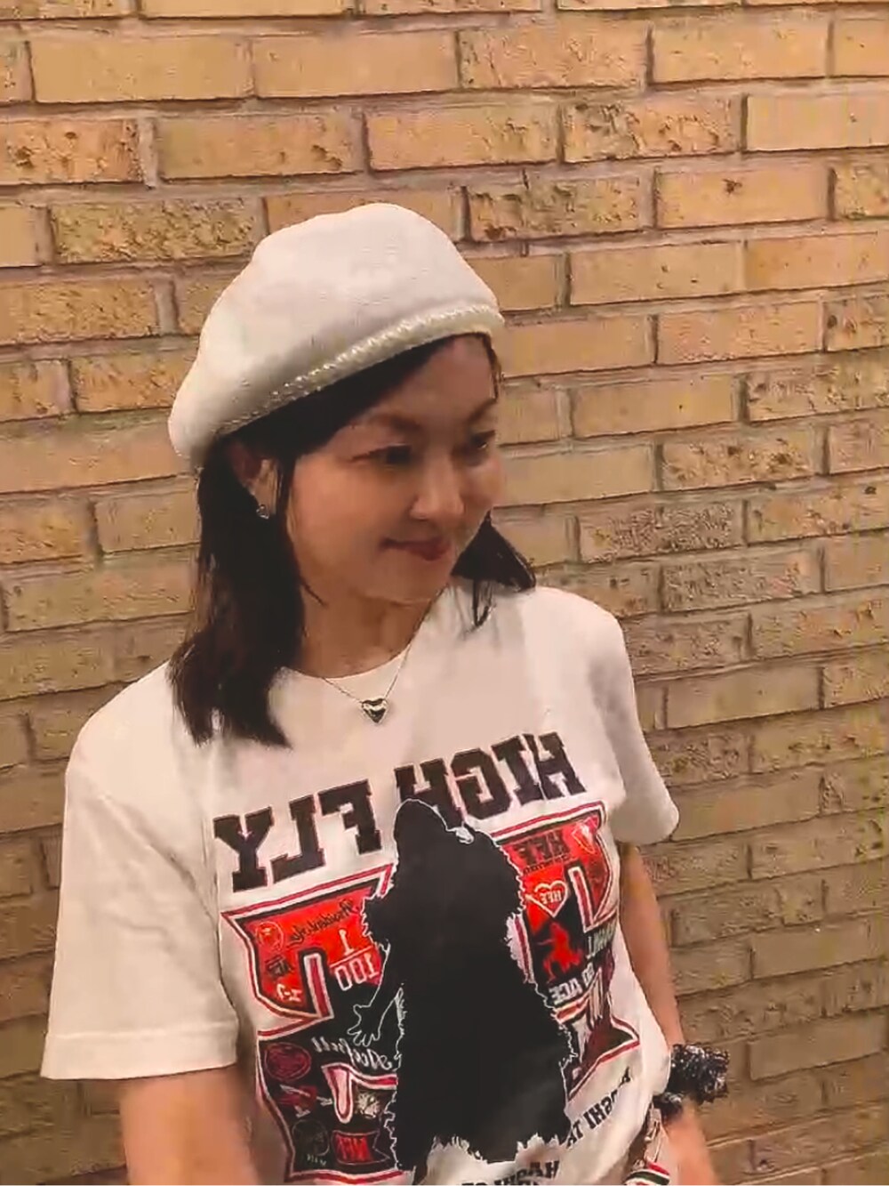 ホワイト系のTシャツ/カットソー、ホワイト系のトートバッグ、ホワイト系のスカートを着用したレディースの秋コーディネートの5枚目の写真