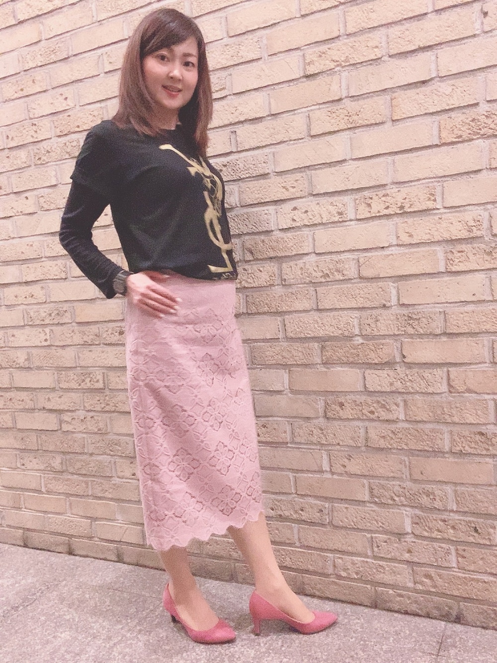 ピンク系のスカート、ピンク系のパンプス、ブラック系のTシャツ/カットソーを着用したレディースの春コーディネートの2枚目の写真