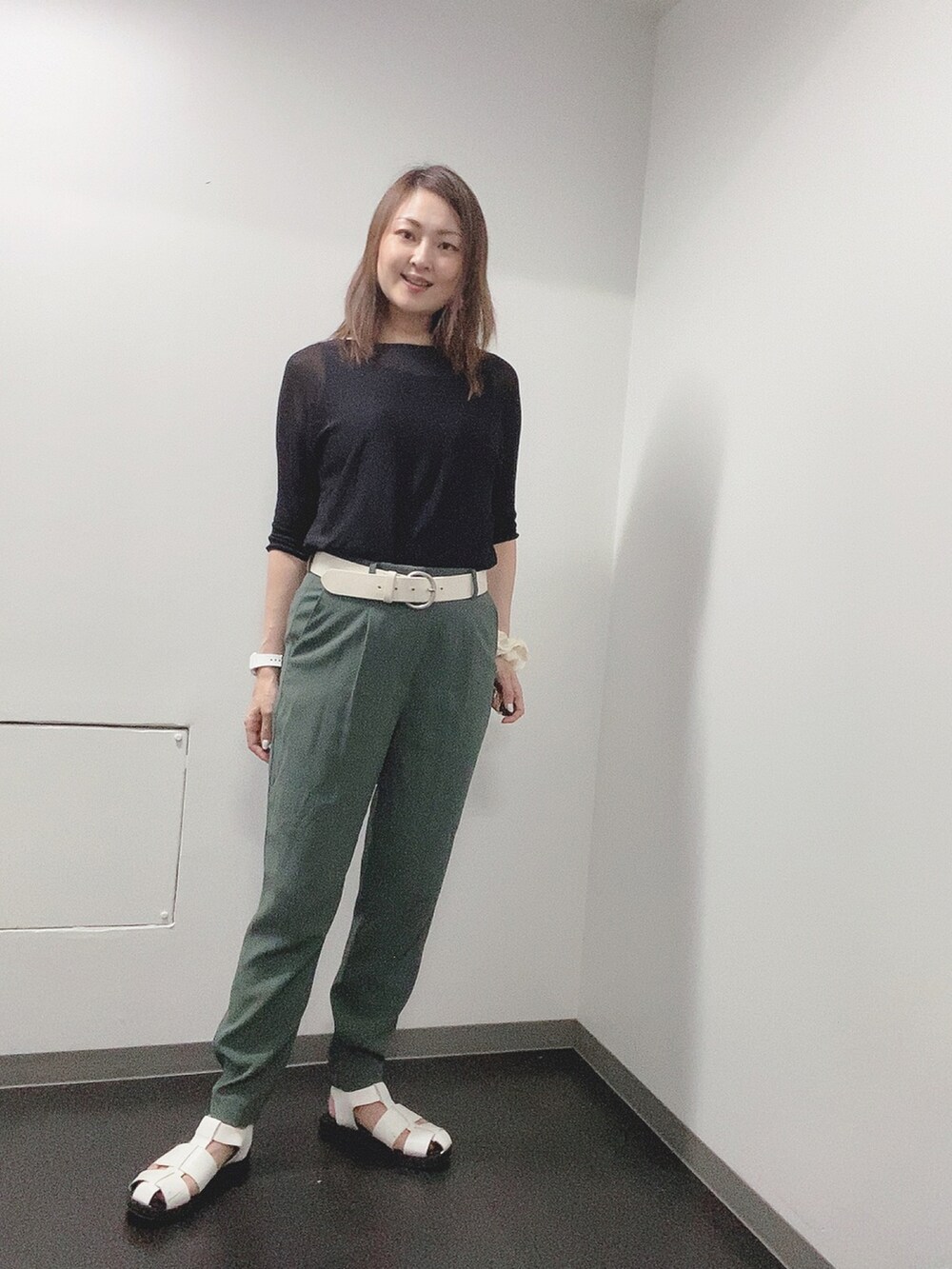 ブラック系のニット/セーター、グリーン系のその他パンツ、ホワイト系のサンダルを着用したレディースの夏コーディネートの3枚目の写真