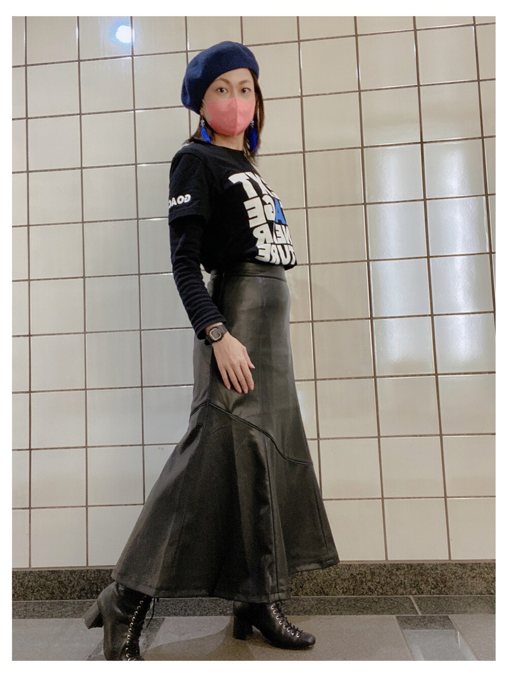 ブラック系のTシャツ/カットソー、ブラック系のスカート、ブラック系のブーツを着用したレディースの秋コーディネートの2枚目の写真