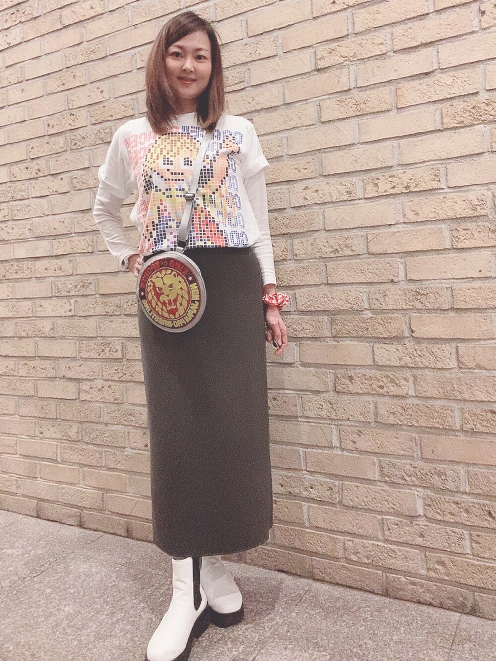 ホワイト系のTシャツ/カットソー、グレー系のスカート、ホワイト系のレインシューズを着用したレディースの春コーディネートの2枚目の写真