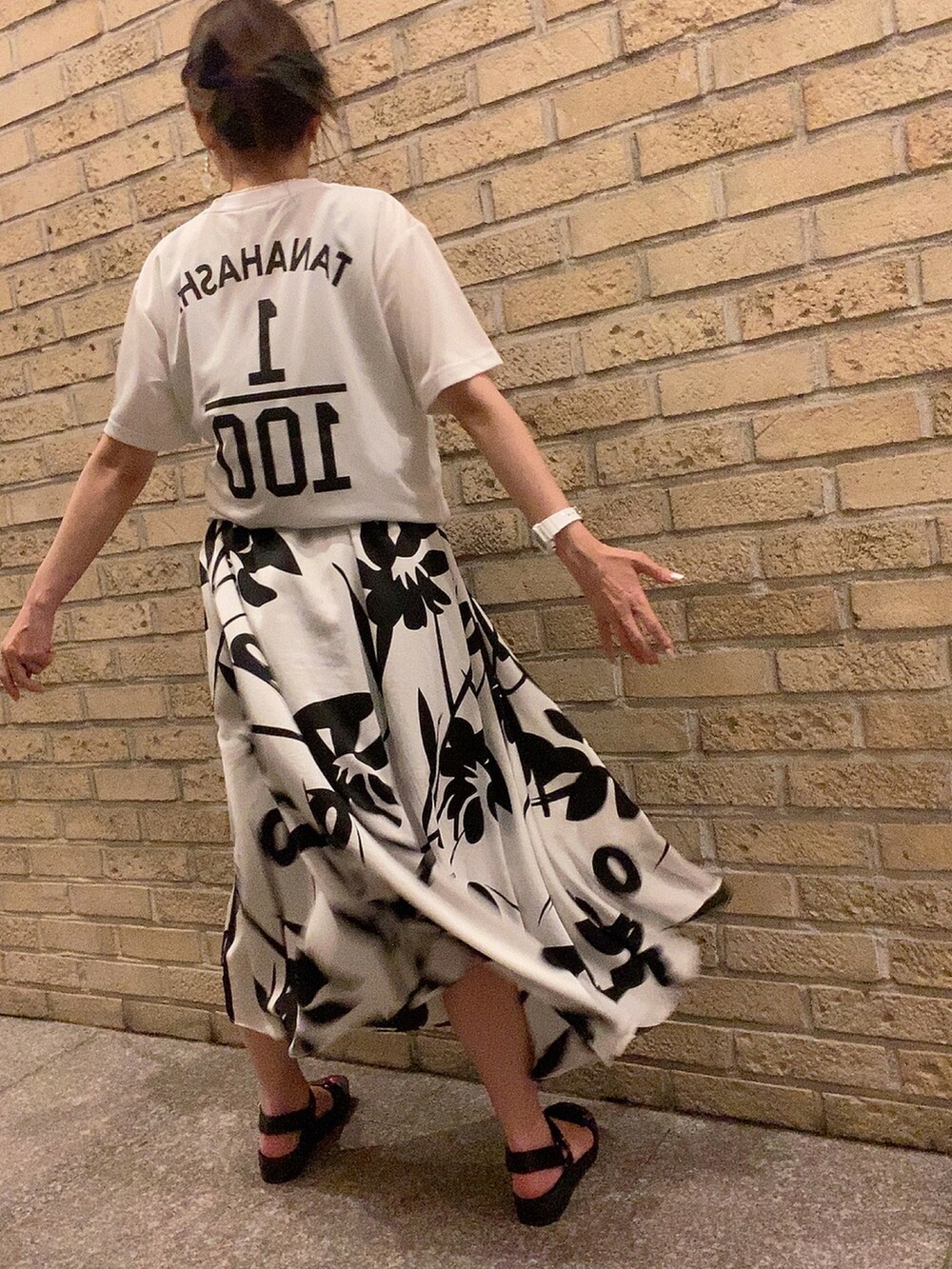 ホワイト系のTシャツ/カットソー、ブラック系のワンピース、ブラック系のサンダルを着用したレディースの夏コーディネートの2枚目の写真