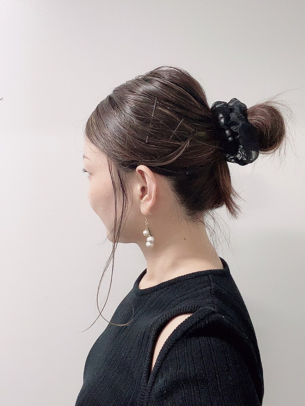 ブラック系のニット/セーター、グリーン系のスカート、ブラック系のレインシューズを着用したレディースの夏コーディネートの4枚目の写真