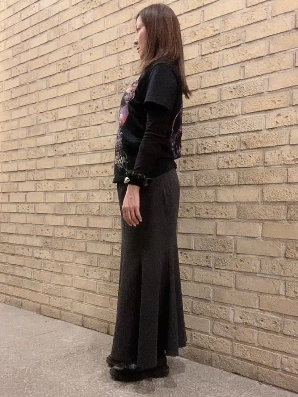 ブラック系のTシャツ/カットソー、ブラック系のスカート、ブラック系のダウンジャケット/コートを着用したレディースの冬コーディネートの3枚目の写真