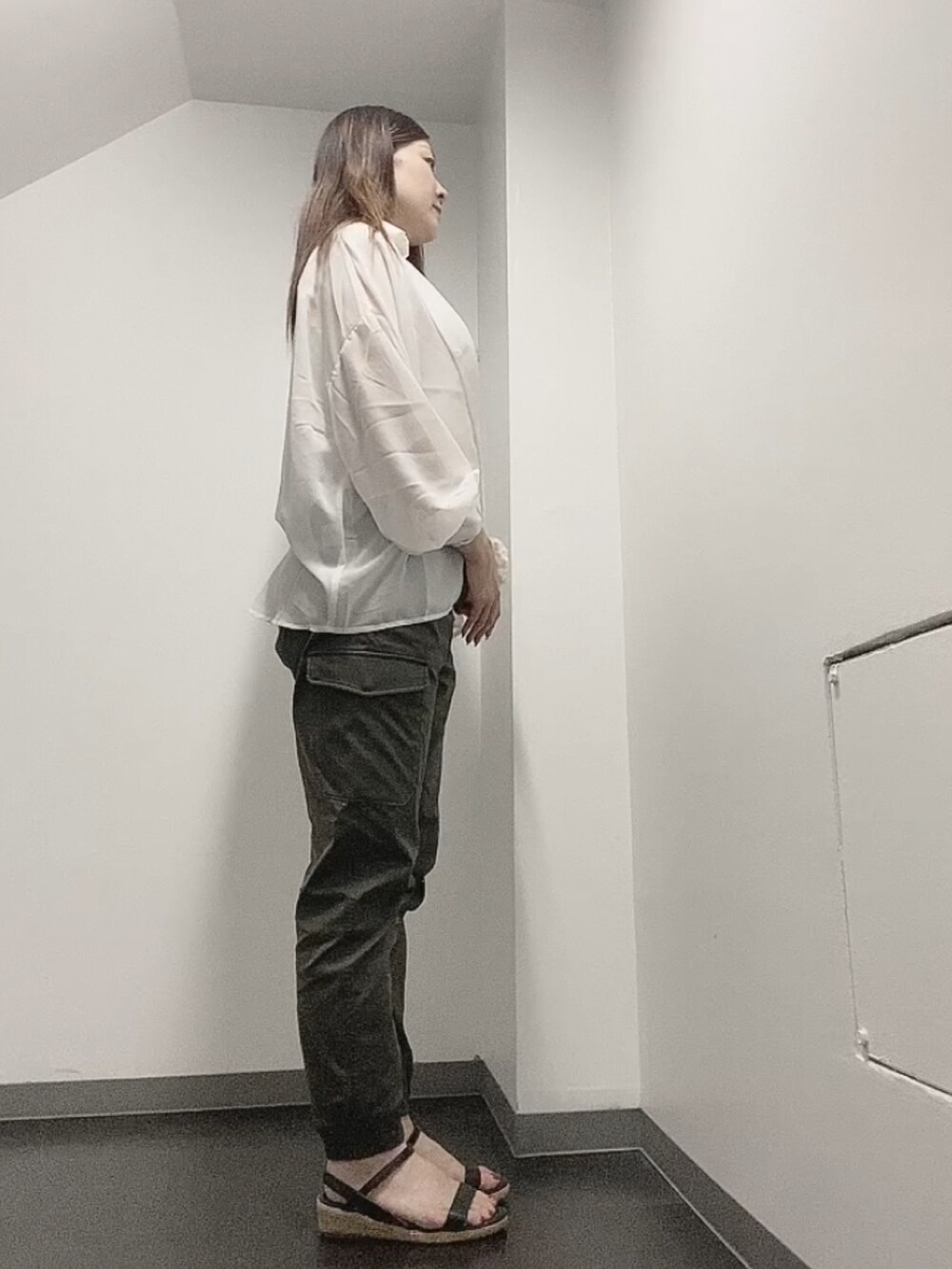 ホワイト系のTシャツ/カットソー、グリーン系のカーゴパンツ、ブラック系のサンダルを着用したレディースの夏コーディネートの2枚目の写真