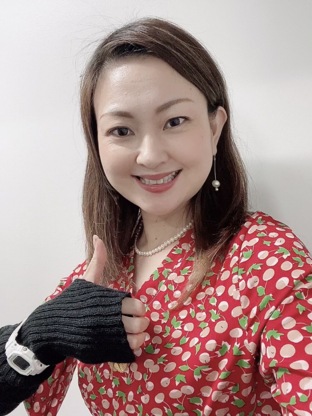 レッド系のワンピース、ホワイト系のレインシューズ、ブラック系のアームカバーを着用したレディースの秋コーディネートの5枚目の写真