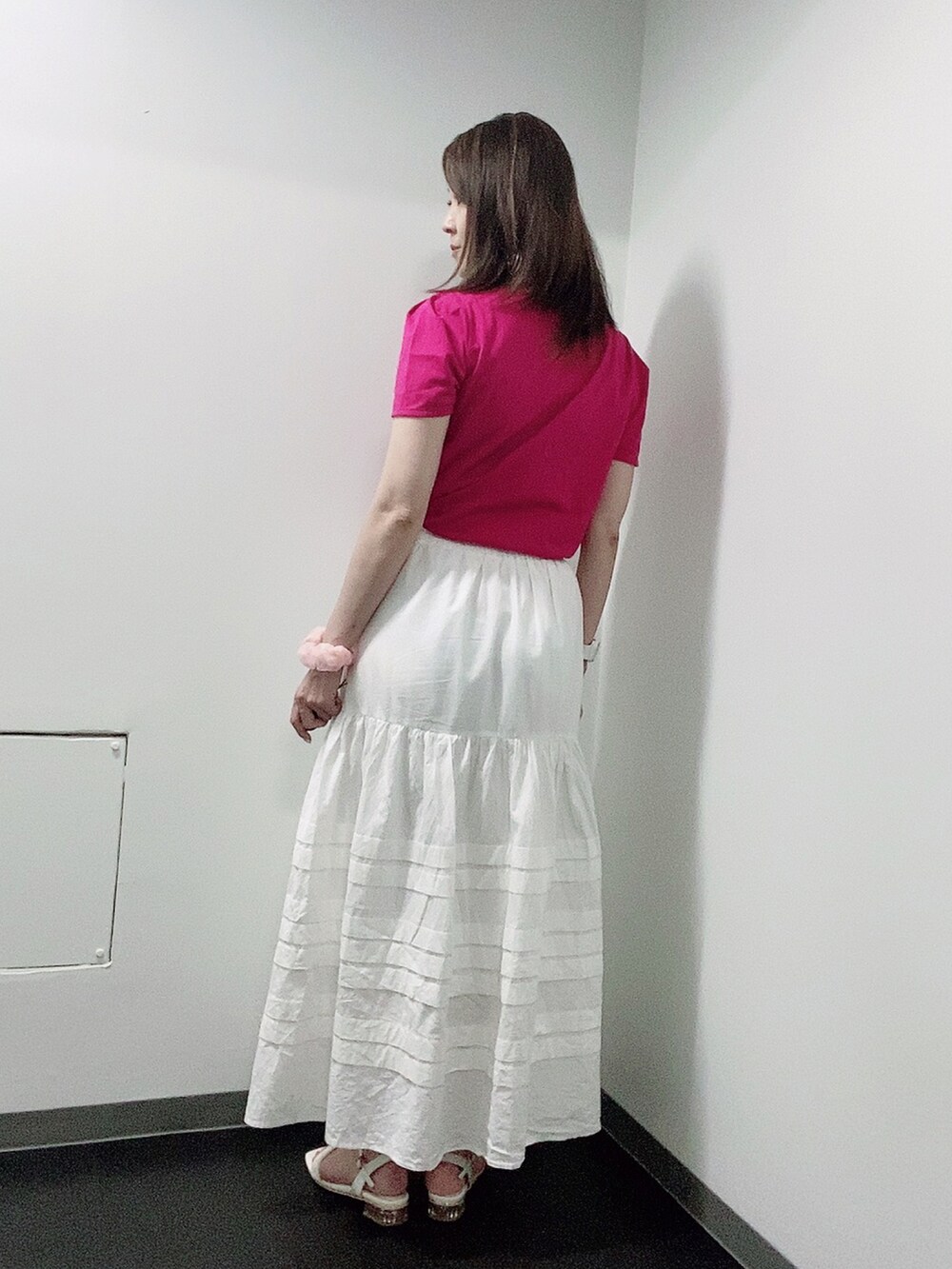 ピンク系のTシャツ/カットソー、ホワイト系のスカート、ホワイト系のサンダルを着用したレディースの夏コーディネートの3枚目の写真