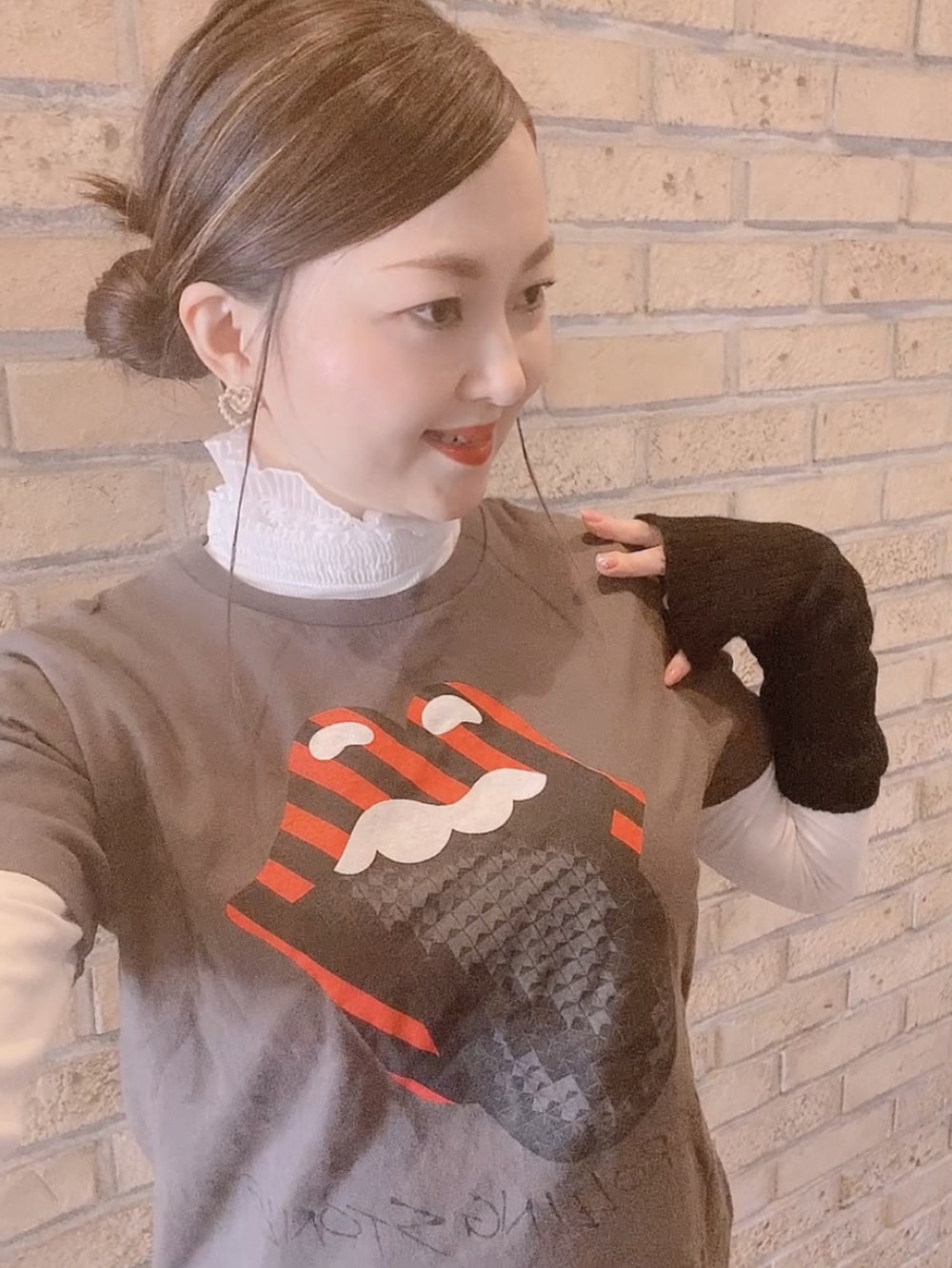 グレー系のTシャツ/カットソー、ブラック系のスカート、ホワイト系のレインシューズを着用したレディースの冬コーディネートの4枚目の写真