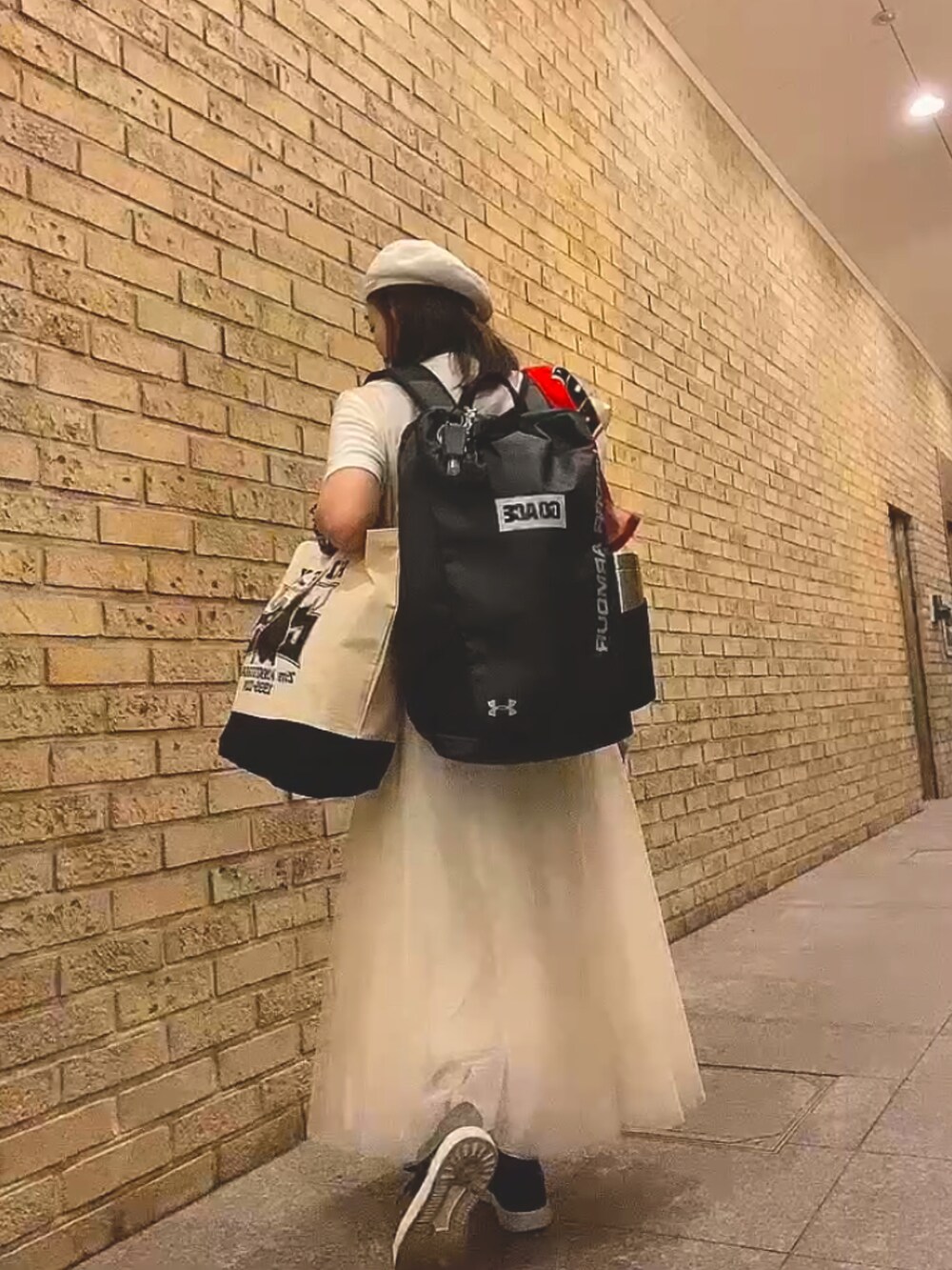 ホワイト系のTシャツ/カットソー、ホワイト系のトートバッグ、ホワイト系のスカートを着用したレディースの秋コーディネートの4枚目の写真