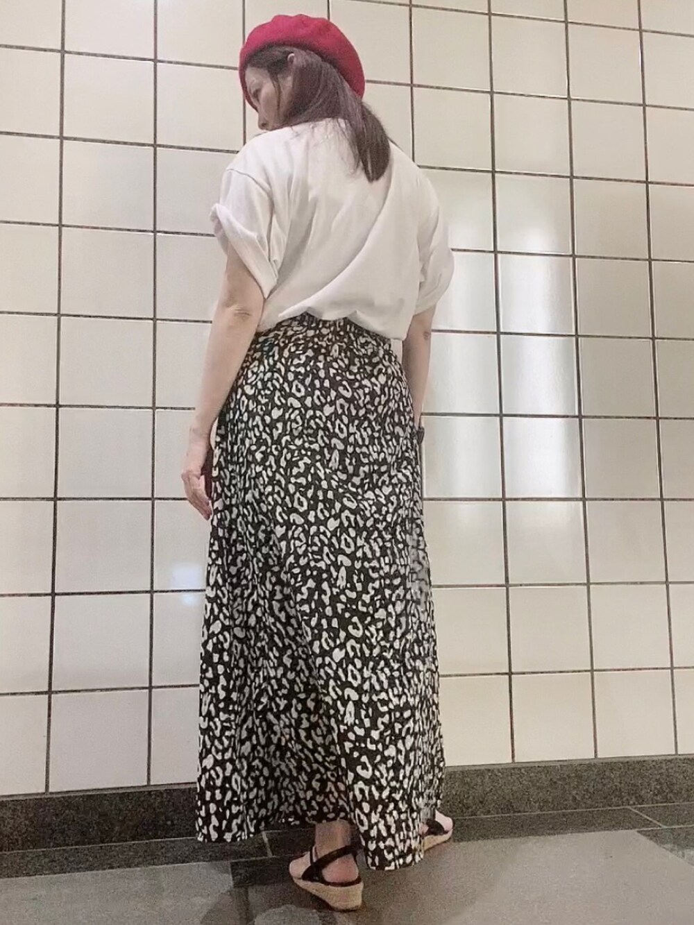 ホワイト系のTシャツ/カットソー、ブラック系のスカート、ブラック系のサンダルを着用したレディースの秋コーディネートの2枚目の写真