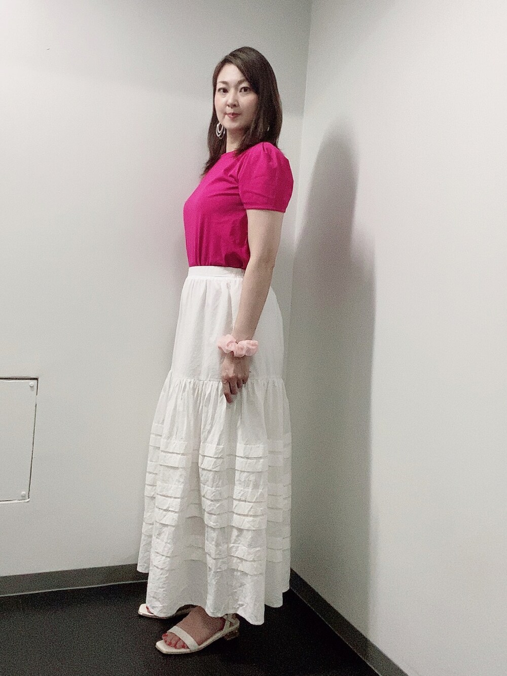 ピンク系のTシャツ/カットソー、ホワイト系のスカート、ホワイト系のサンダルを着用したレディースの夏コーディネートの2枚目の写真