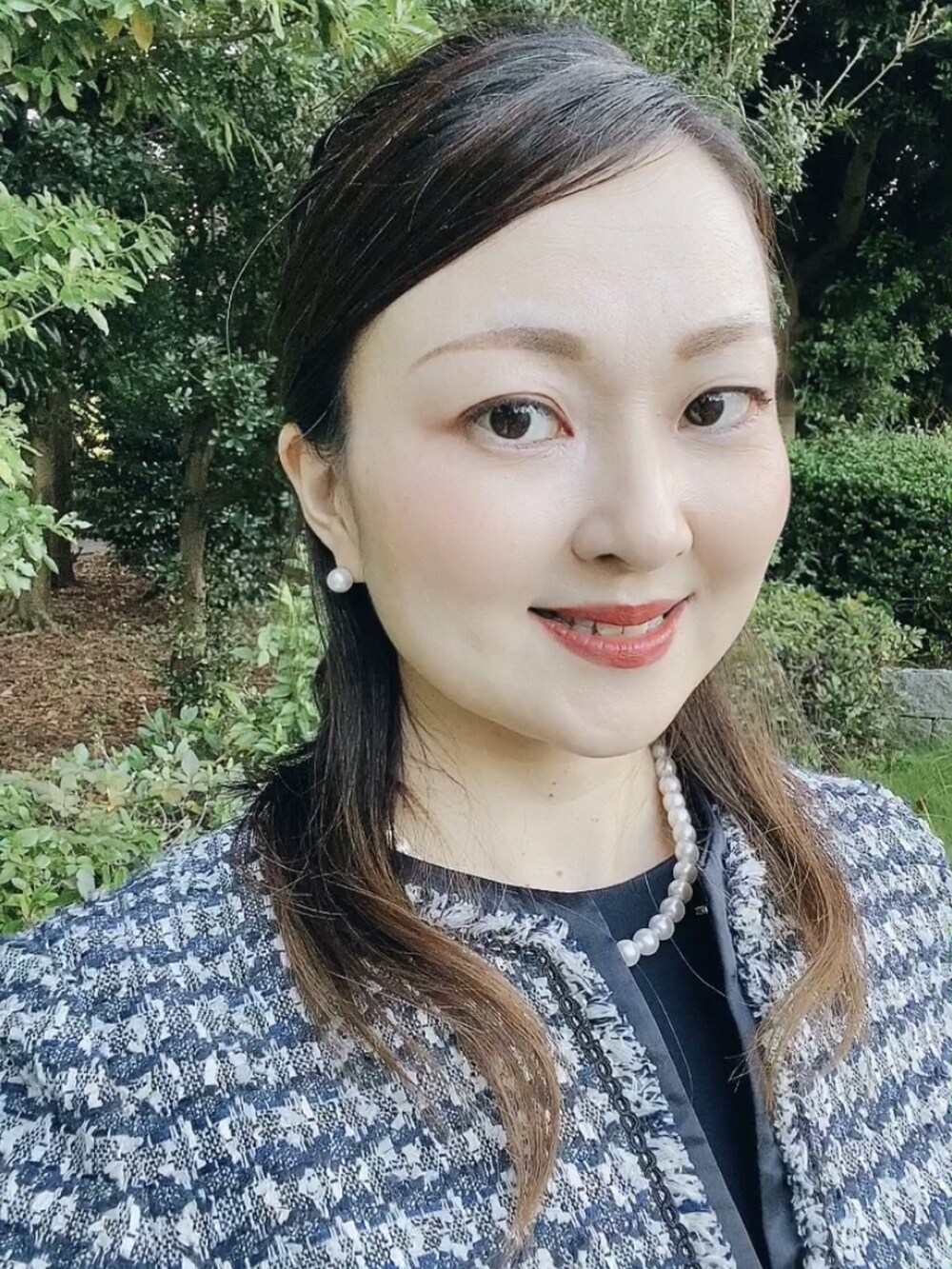 ブルー系のスーツセット、ベージュ系のパンプス、ホワイト系のネックレスを着用したレディースの秋コーディネートの4枚目の写真