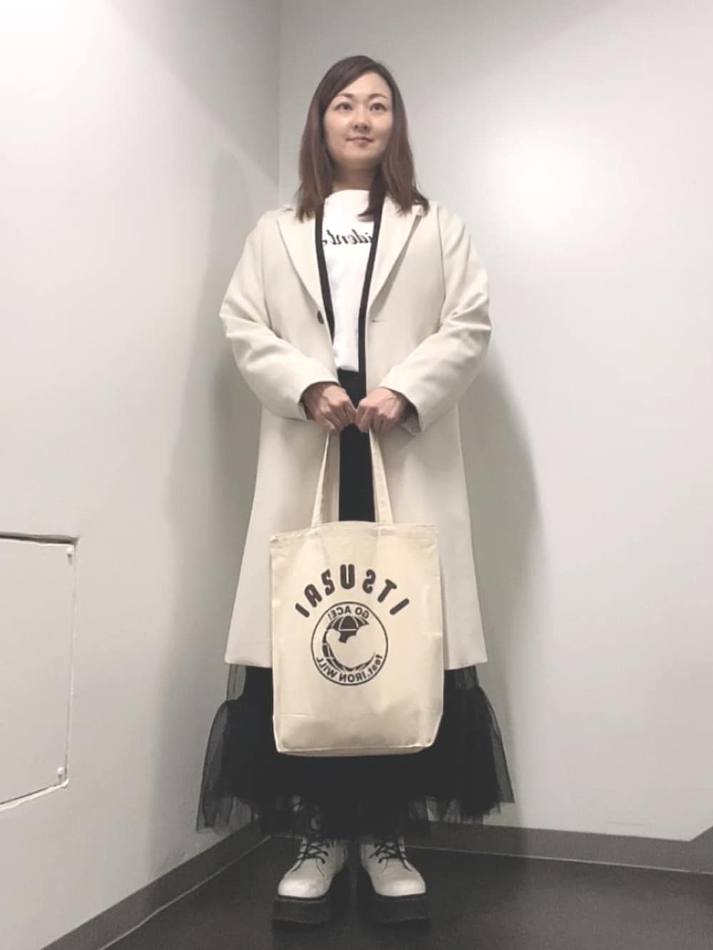 ホワイト系のTシャツ/カットソー、ブラック系のベスト、ブラック系のスカートを着用したレディースの春コーディネートの2枚目の写真