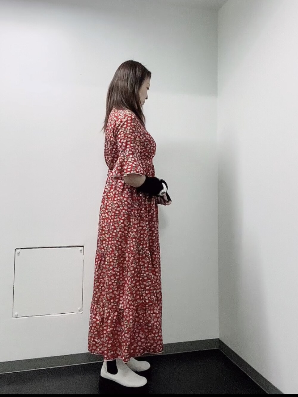 レッド系のワンピース、ホワイト系のレインシューズ、ブラック系のアームカバーを着用したレディースの秋コーディネートの4枚目の写真