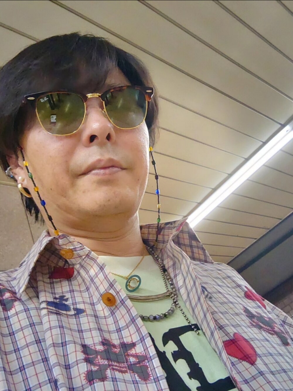 ベージュ系のシャツワンピースを着用したメンズの夏コーディネートの4枚目の写真