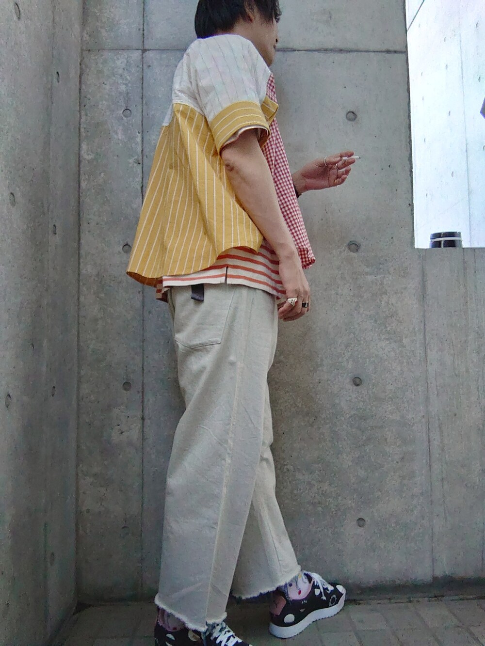 レッド系のシャツ/ブラウス、ブルー系のデニムパンツ、ブラック系のスニーカーを着用したメンズの夏コーディネートの3枚目の写真