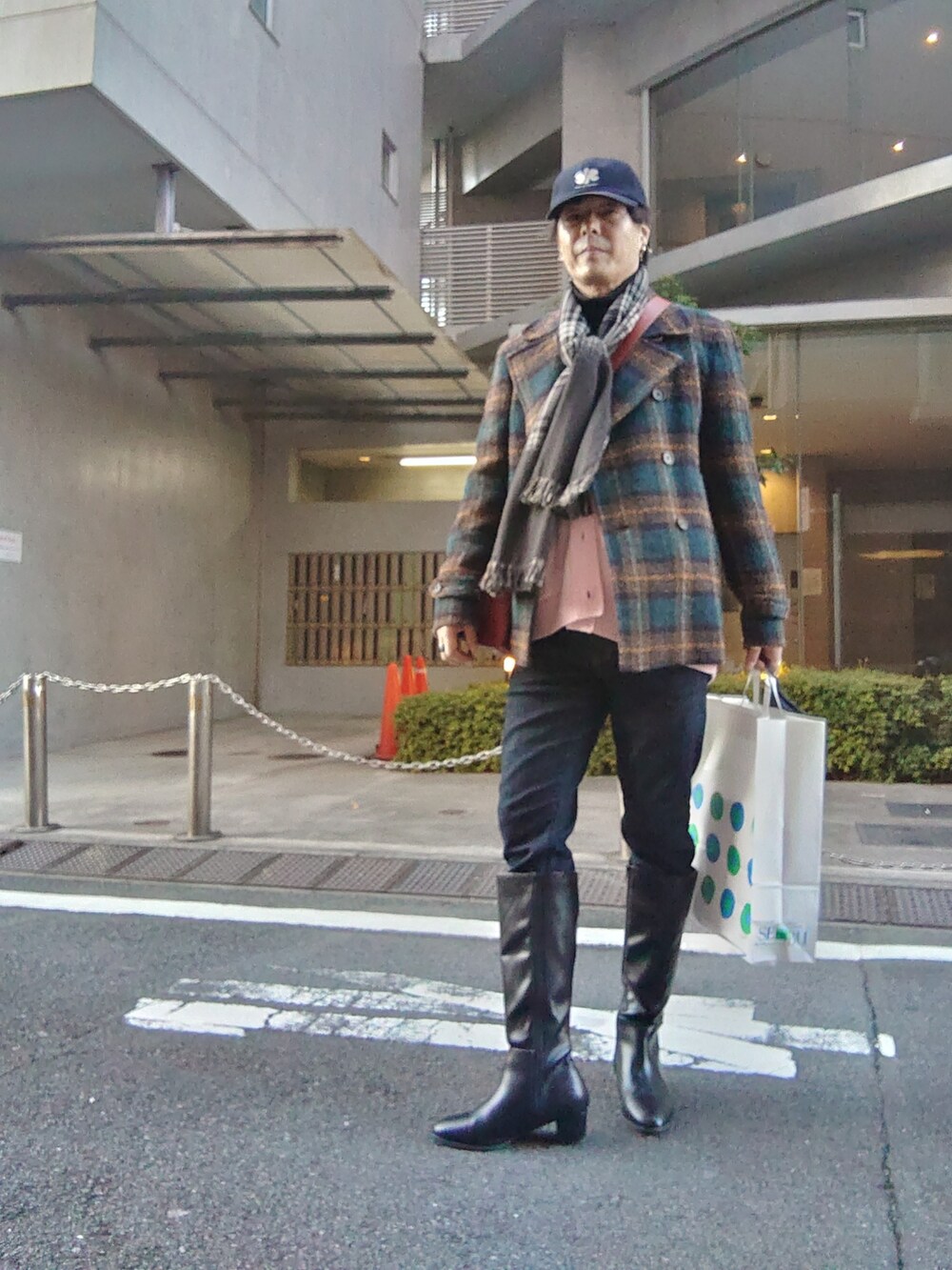 ブラック系のブーツ、ブルー系のデニムパンツ、グリーン系のピーコートを着用したメンズの冬コーディネートの3枚目の写真