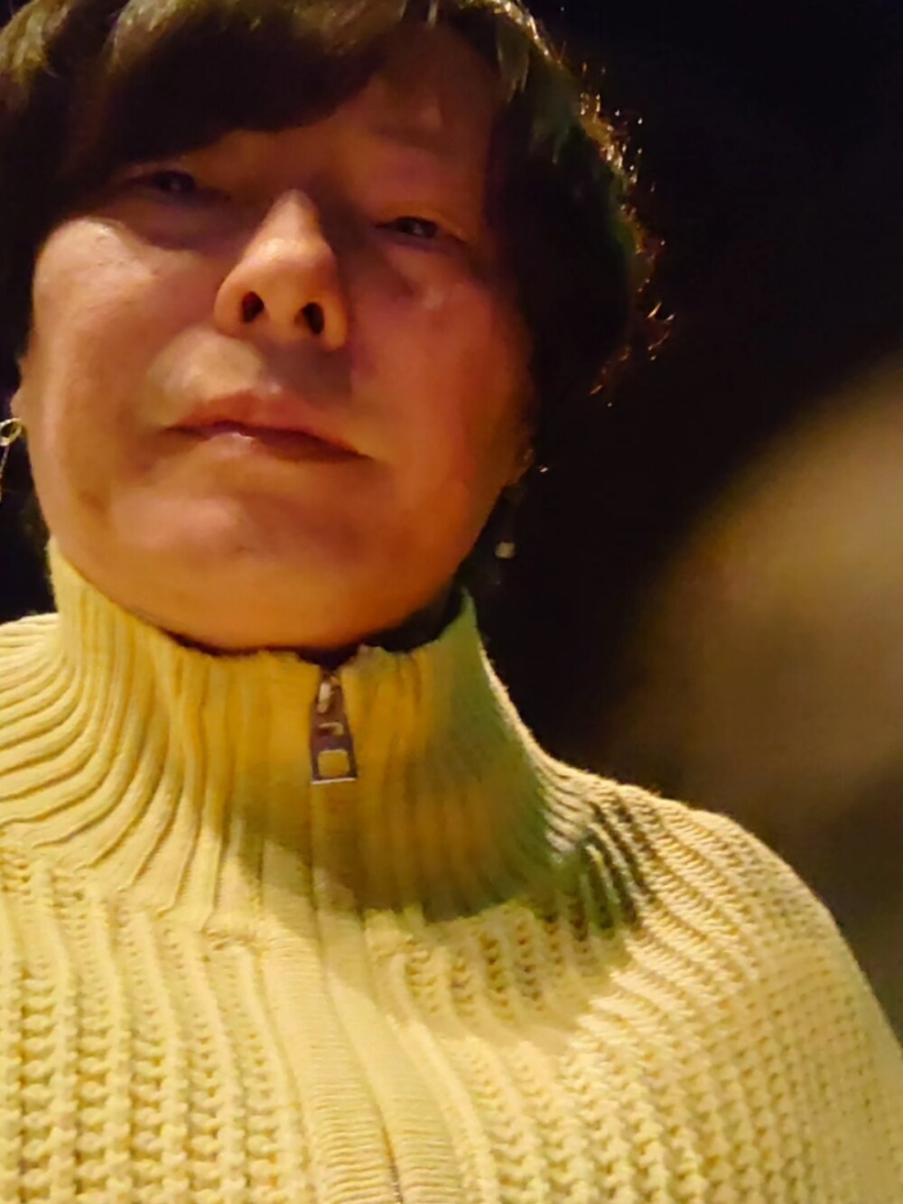 イエロー系のベスト、ブラック系のパーカー、ベージュ系のその他パンツを着用したメンズの冬コーディネートの3枚目の写真