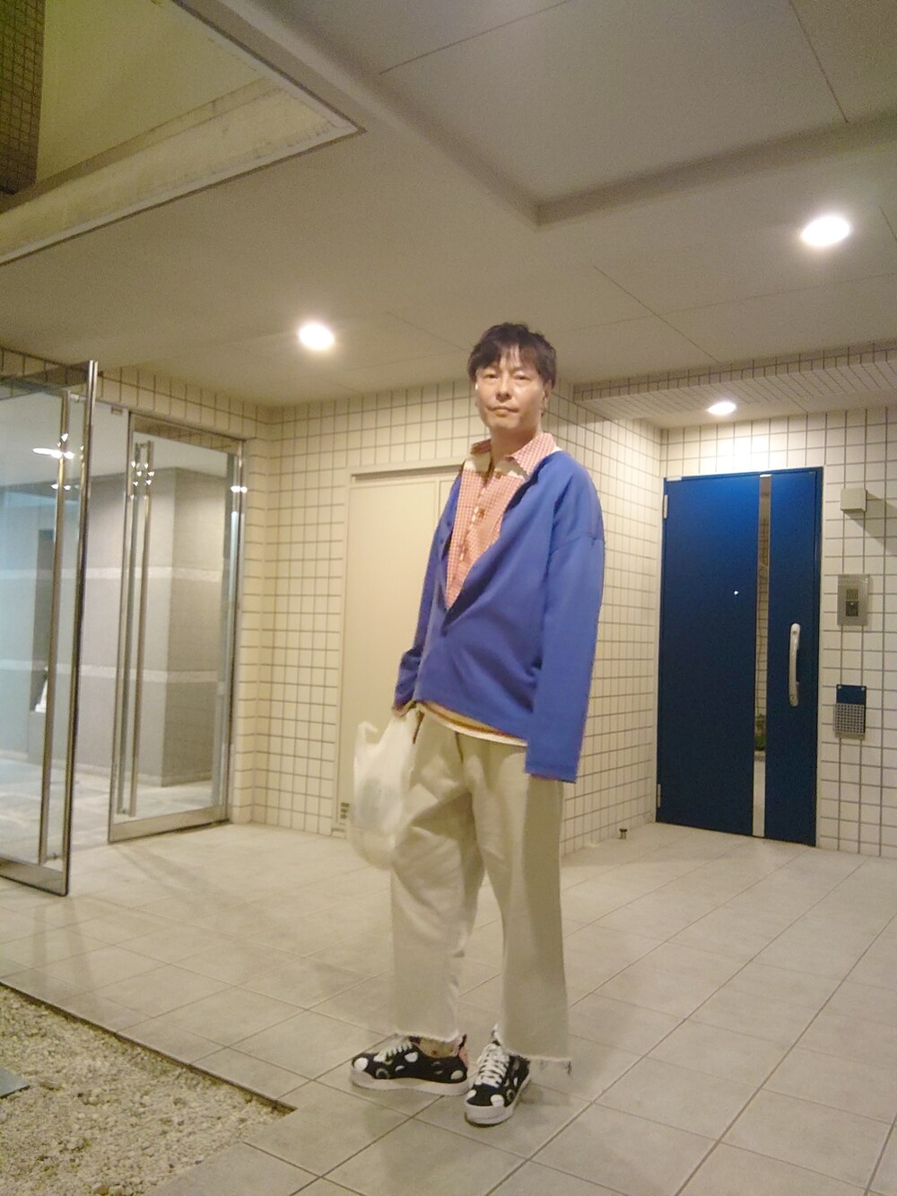 レッド系のシャツ/ブラウス、ブルー系のデニムパンツ、ブラック系のスニーカーを着用したメンズの夏コーディネートの5枚目の写真