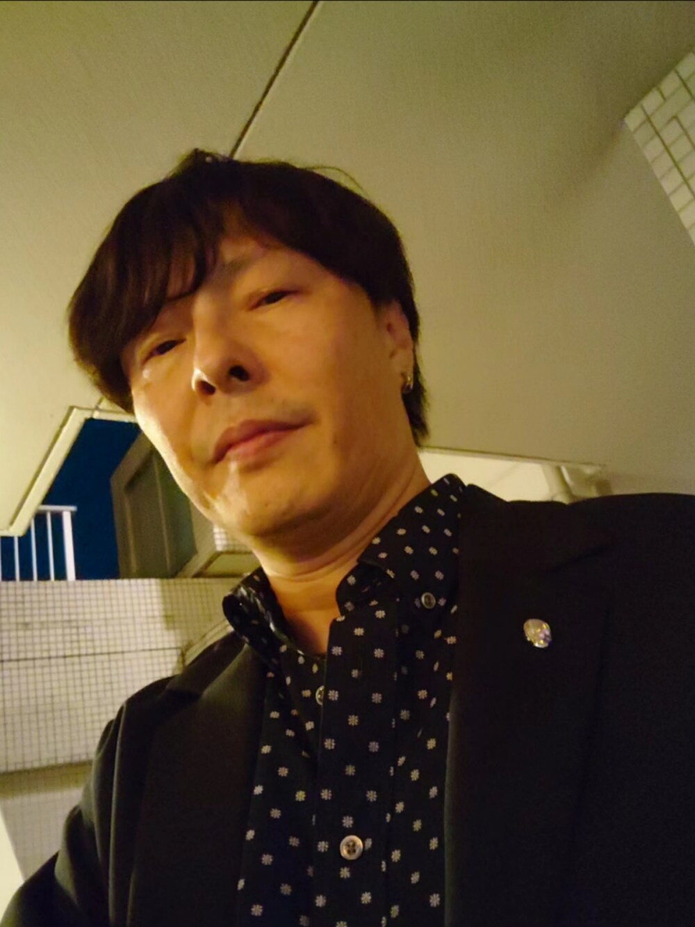 ブルー系のセットアップ、ブラック系のブーツを着用したメンズの秋コーディネートの5枚目の写真