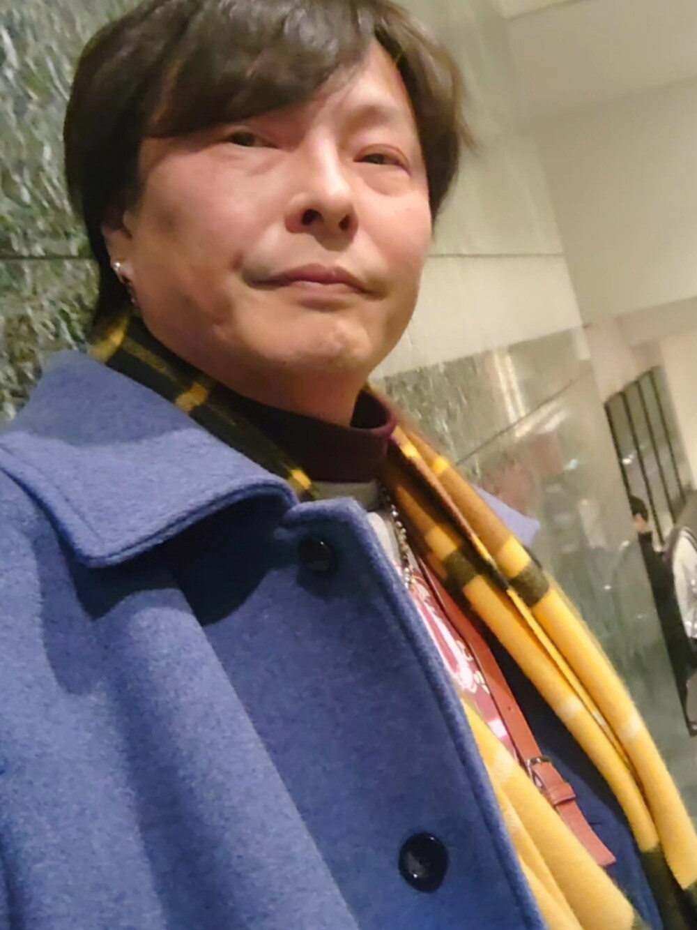 ブラック系のブーツ、グレー系のその他パンツ、ブルー系のステンカラーコートを着用したメンズの冬コーディネートの2枚目の写真