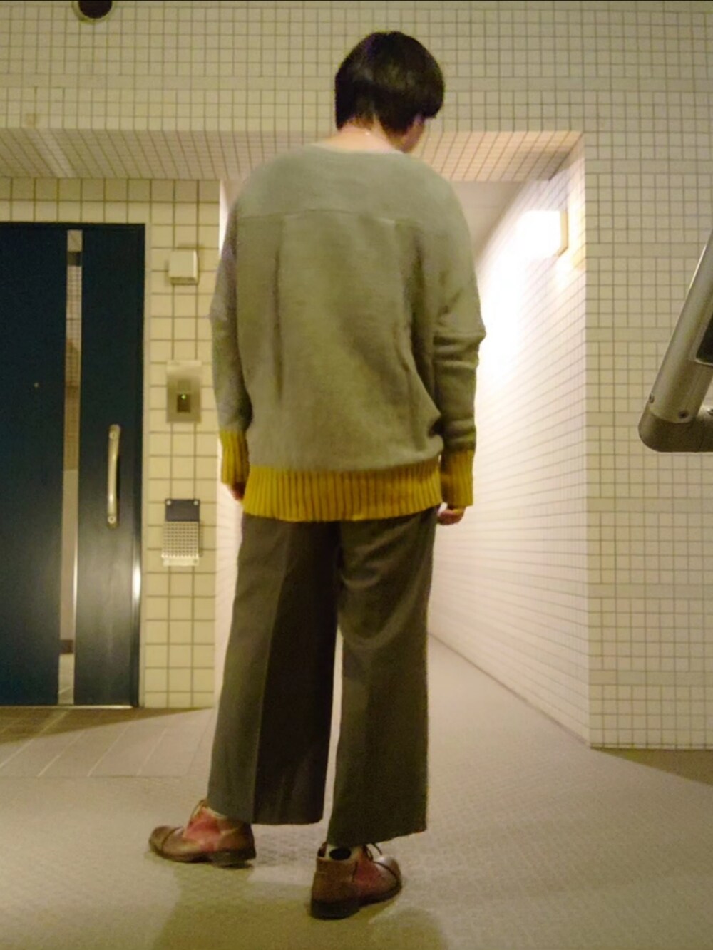 グレー系のスラックス、グレー系のニット/セーター、グレー系のトレンチコートを着用したメンズの冬コーディネートの4枚目の写真