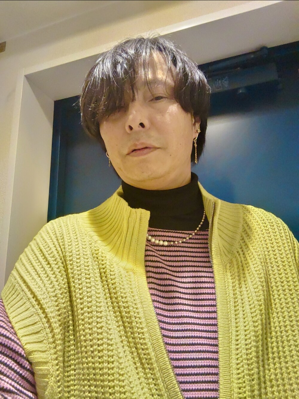 イエロー系のベスト、ピンク系のTシャツ/カットソー、ベージュ系のその他パンツを着用したメンズの冬コーディネートの3枚目の写真