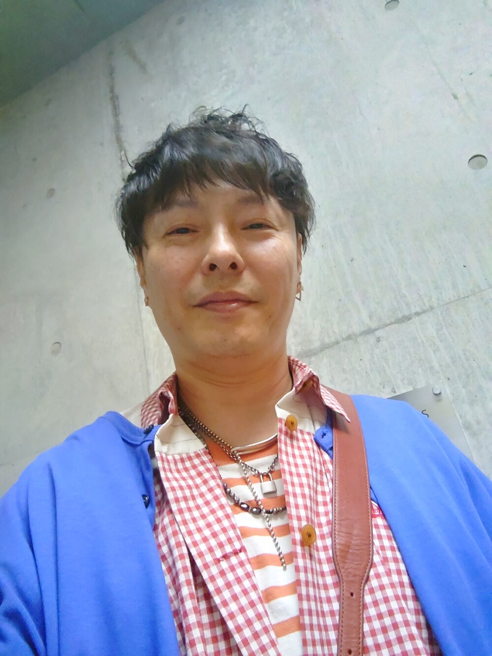 レッド系のシャツ/ブラウス、ブルー系のデニムパンツ、ブラック系のスニーカーを着用したメンズの夏コーディネートの4枚目の写真