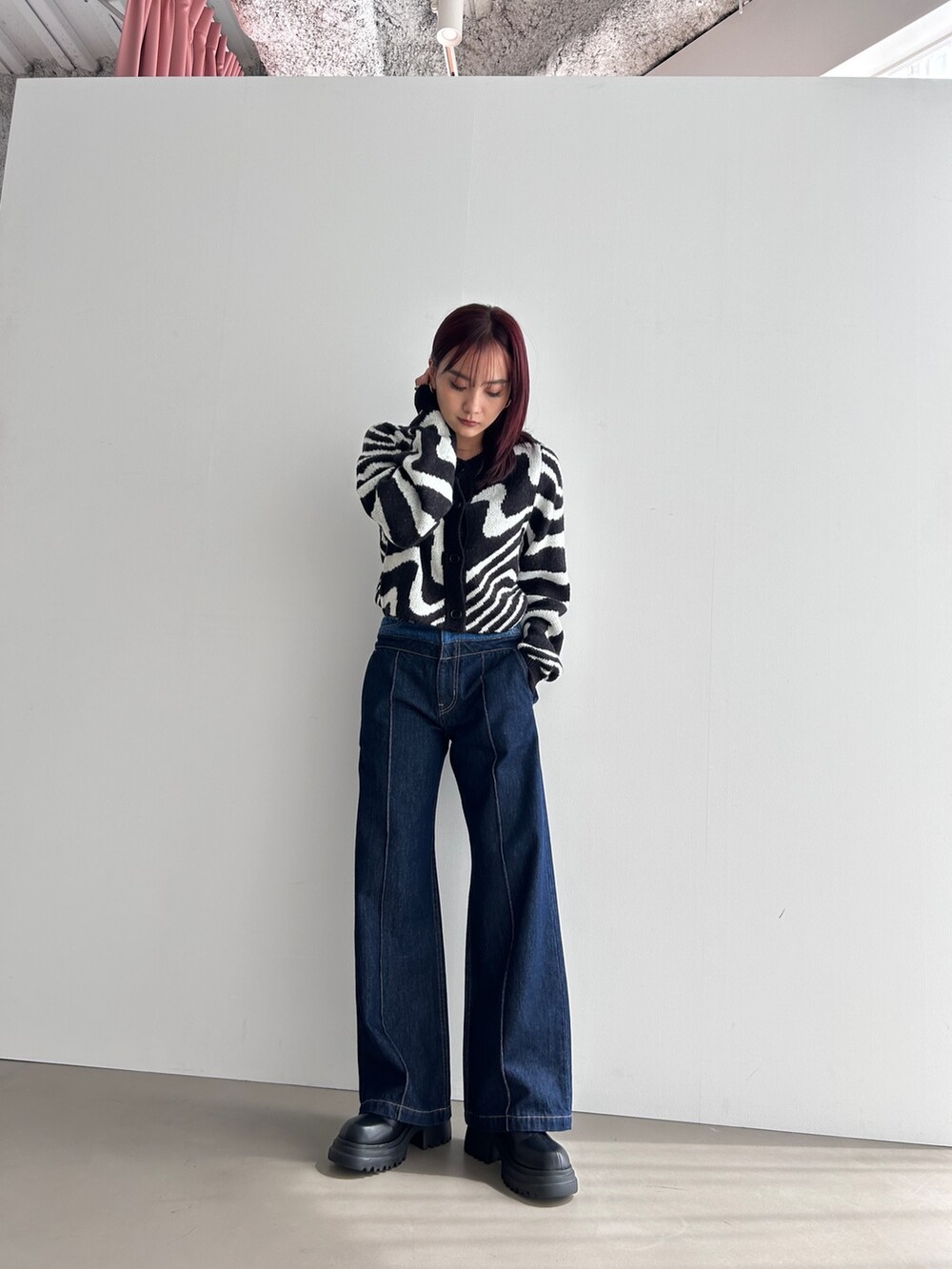 ブラック系のカーディガン/ボレロ、ブルー系のデニムパンツ、ブラック系のブーツを着用したレディースの冬コーディネートの3枚目の写真