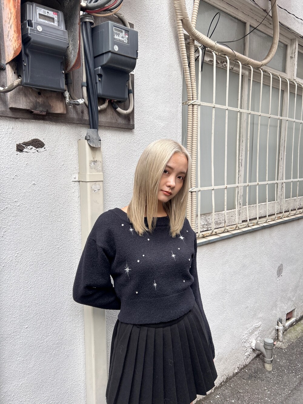 ブラック系のニット/セーター、ブラック系のスカート、その他のブーツを着用したレディースの冬コーディネートの8枚目の写真