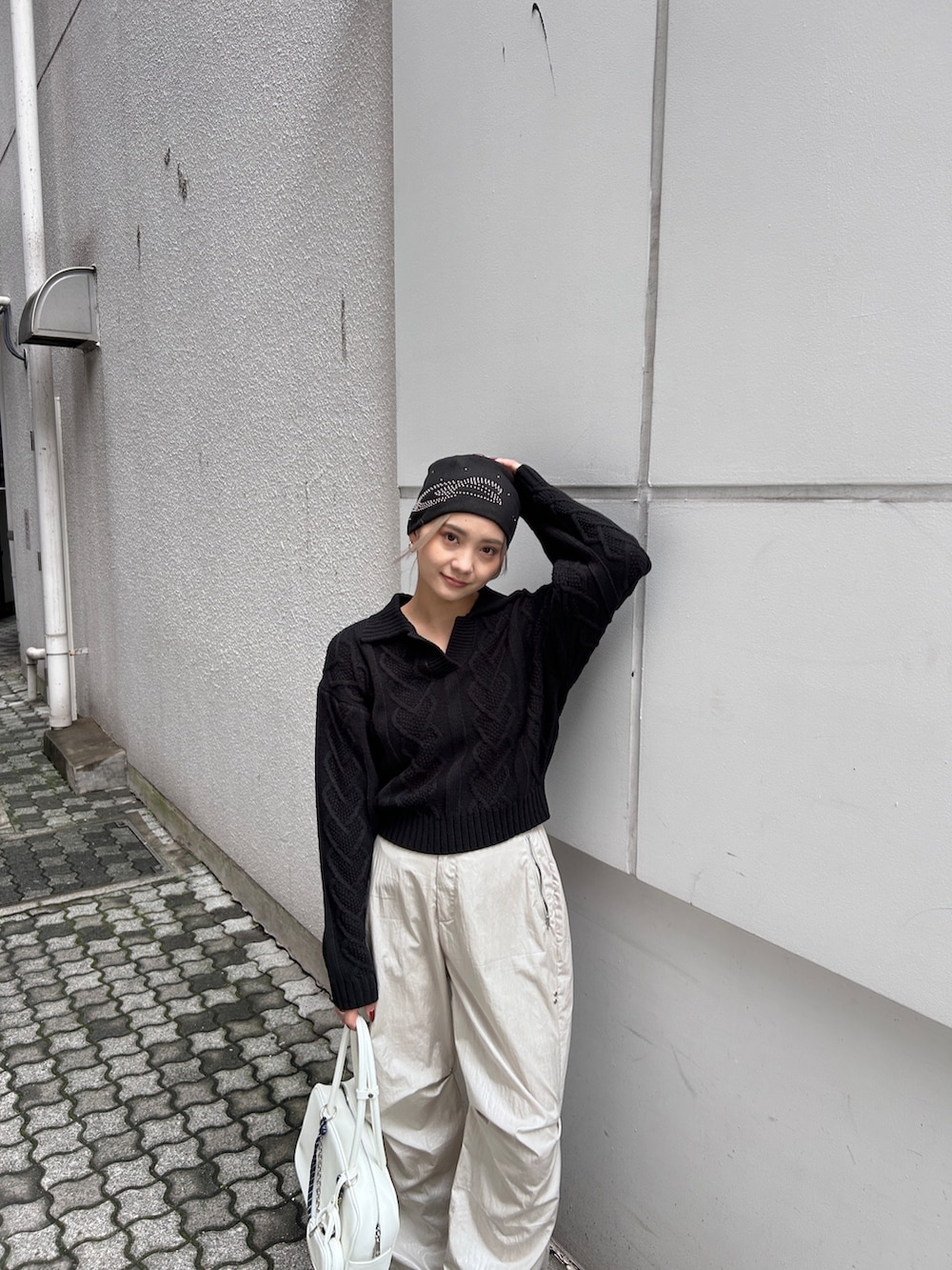 レッド系のニット/セーター、ホワイト系のその他パンツ、ブラック系のブーツを着用したレディースの秋コーディネートの4枚目の写真