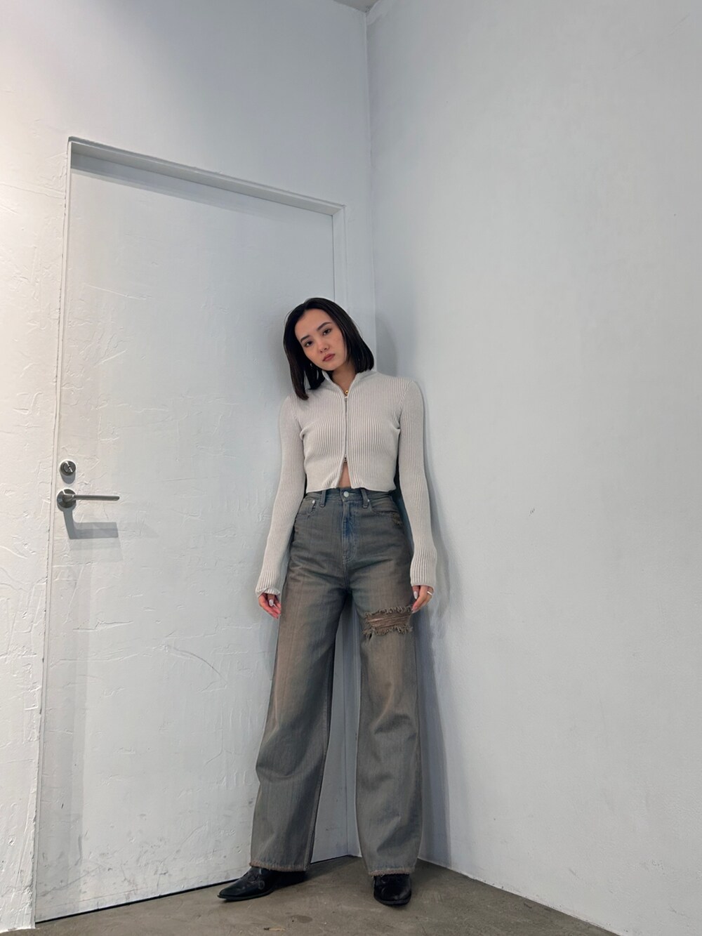 ホワイト系のニット/セーター、グレー系のデニムパンツを着用したレディースの冬コーディネートの2枚目の写真