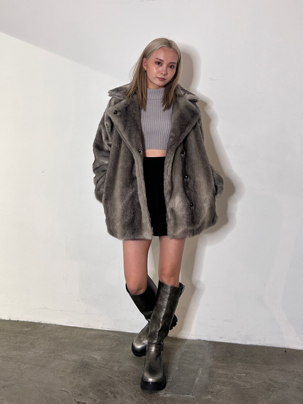 グレー系のその他アウター、グレー系のニット/セーター、シルバー系のブーツを着用したレディースの冬コーディネートの2枚目の写真