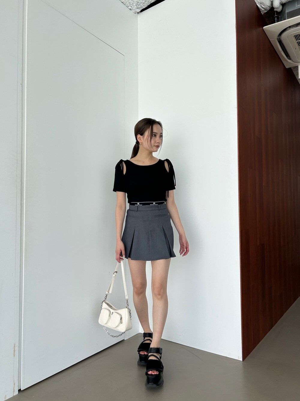 ブラック系のTシャツ/カットソー、グレー系のスカートを着用したレディースの春コーディネートの2枚目の写真