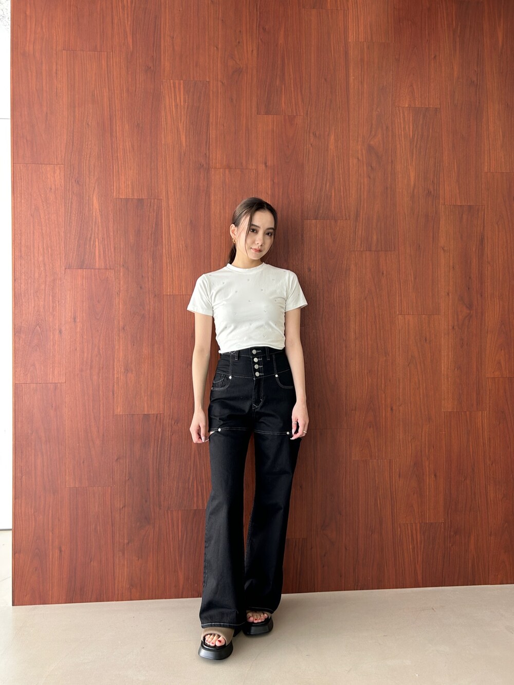 ホワイト系のTシャツ/カットソー、ブラック系のデニムパンツ、ブラウン系のサンダルを着用したレディースの春コーディネートの2枚目の写真