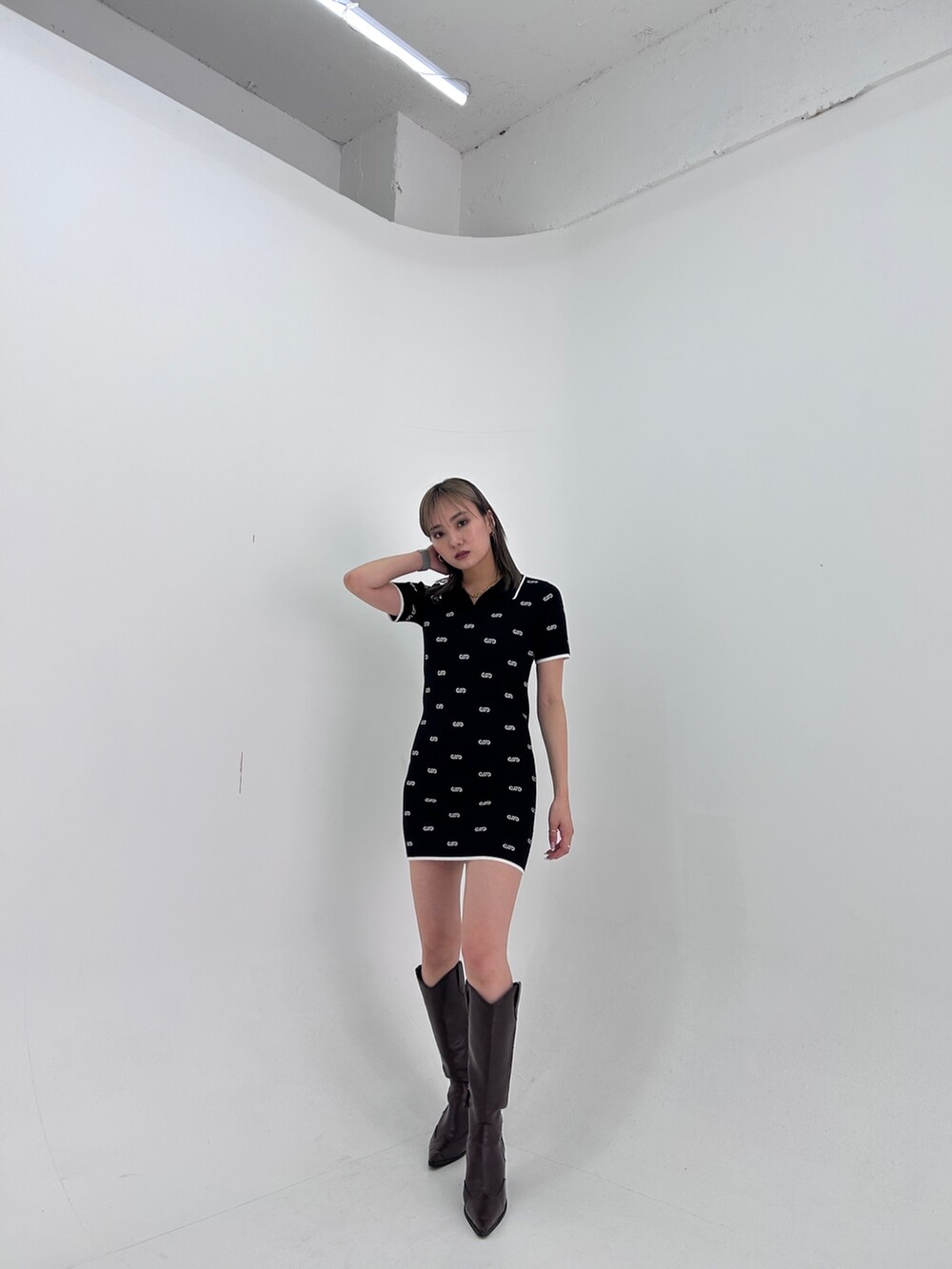 ブラック系のワンピース、ブラック系のブーツを着用したレディースの春コーディネートの3枚目の写真