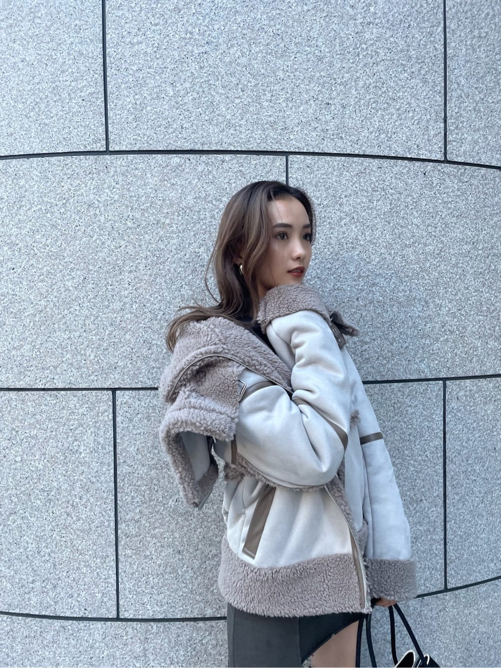 グレー系のムートンコートを着用したレディースの冬コーディネートの2枚目の写真