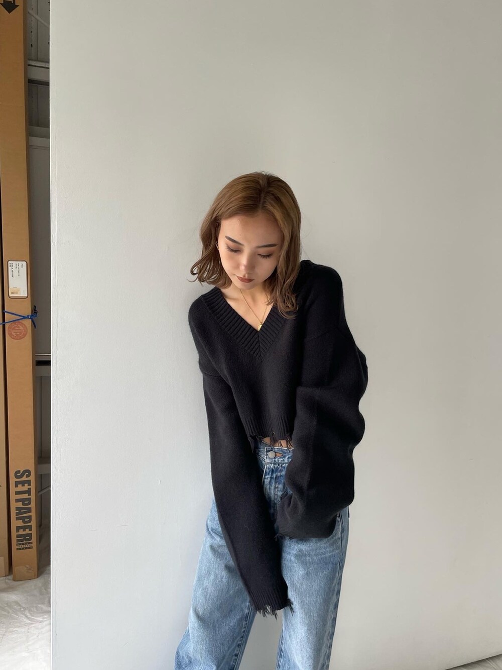 ブラック系のニット/セーター、ブルー系のデニムパンツを着用したレディースの冬コーディネートの2枚目の写真