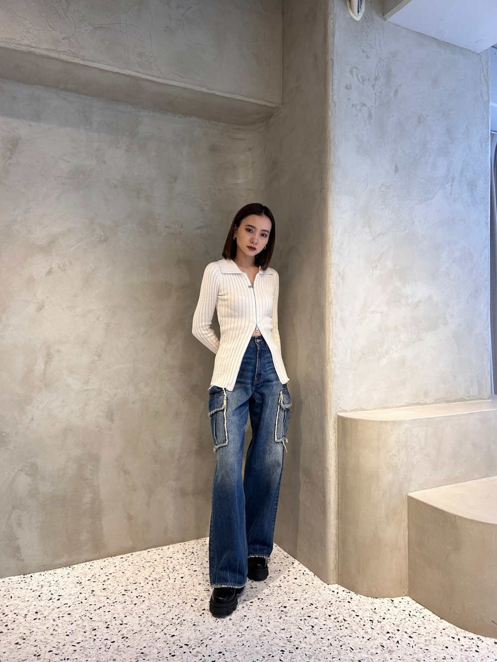 ホワイト系のニット/セーター、ブルー系のデニムパンツを着用したレディースの春コーディネートの2枚目の写真