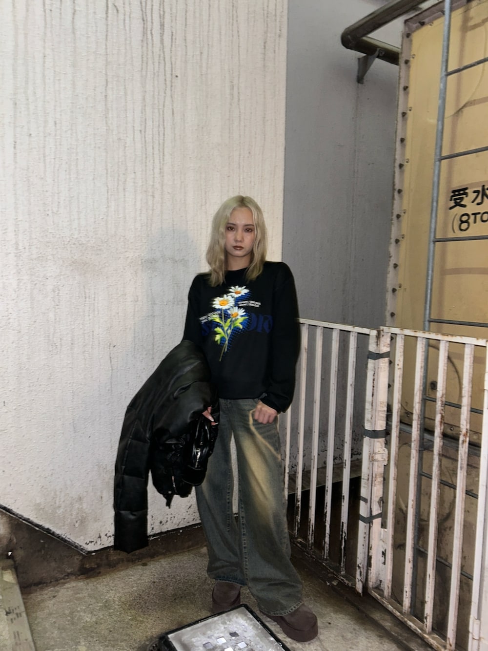 ブラック系のニット/セーター、ブルー系のデニムパンツを着用したレディースの冬コーディネートの2枚目の写真