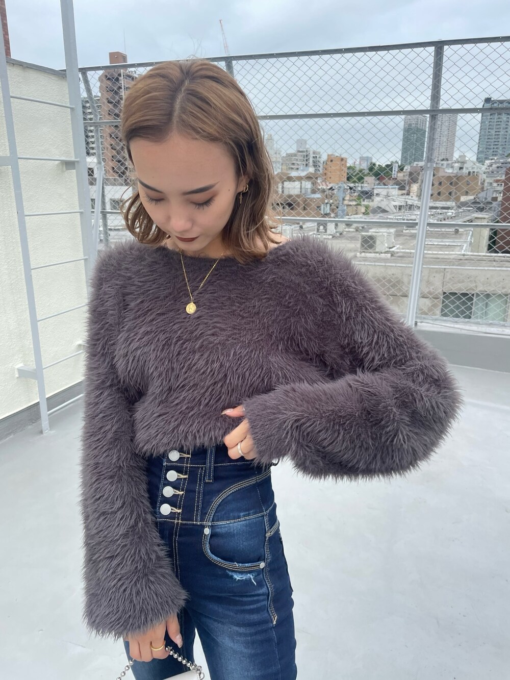 グレー系のニット/セーター、ブルー系のデニムパンツを着用したレディースの冬コーディネートの4枚目の写真