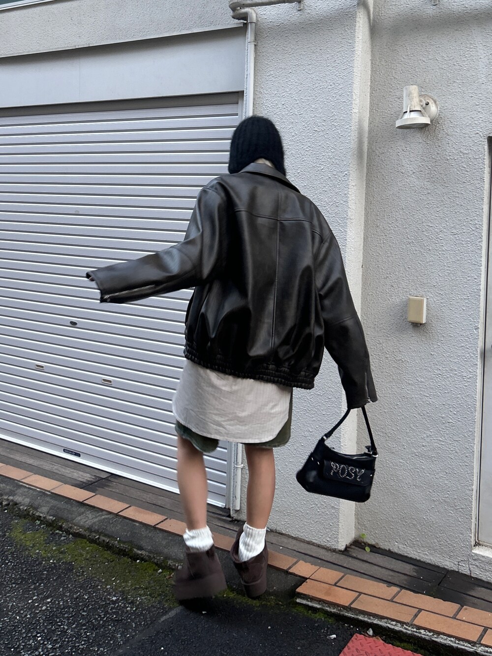 ブラック系のブルゾン、ブラウン系のデニムパンツ、ブラック系のハンドバッグを着用したレディースの冬コーディネートの3枚目の写真