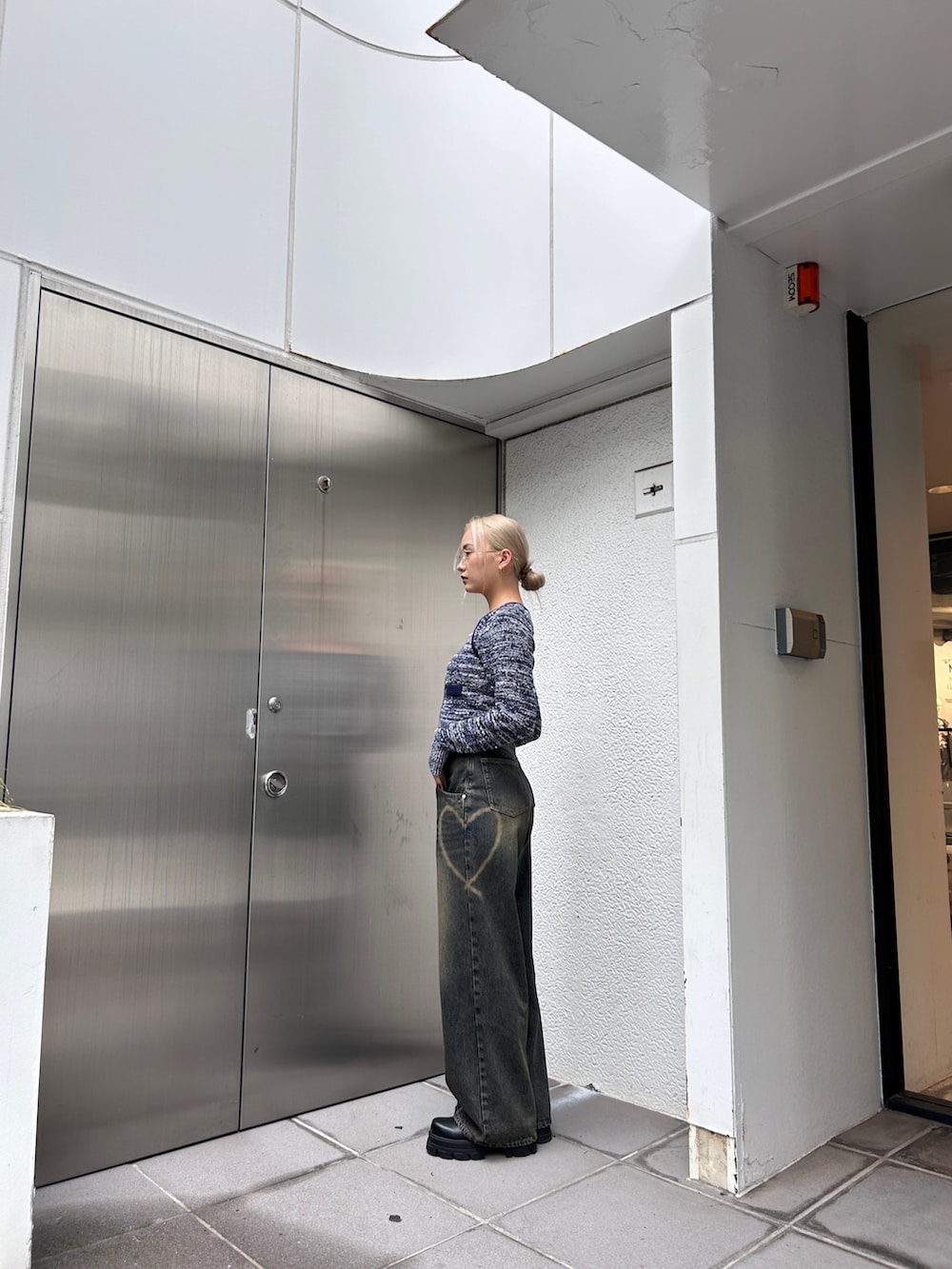 ブルー系のニット/セーター、ブルー系のデニムパンツを着用したレディースの秋コーディネートの4枚目の写真