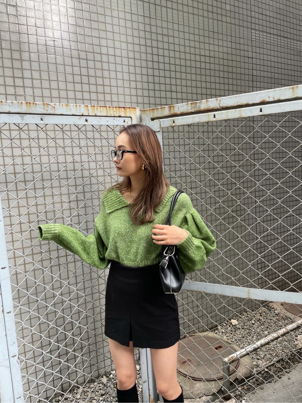 ブラック系のスカート、グリーン系のニット/セーターを着用したレディースの冬コーディネートの2枚目の写真