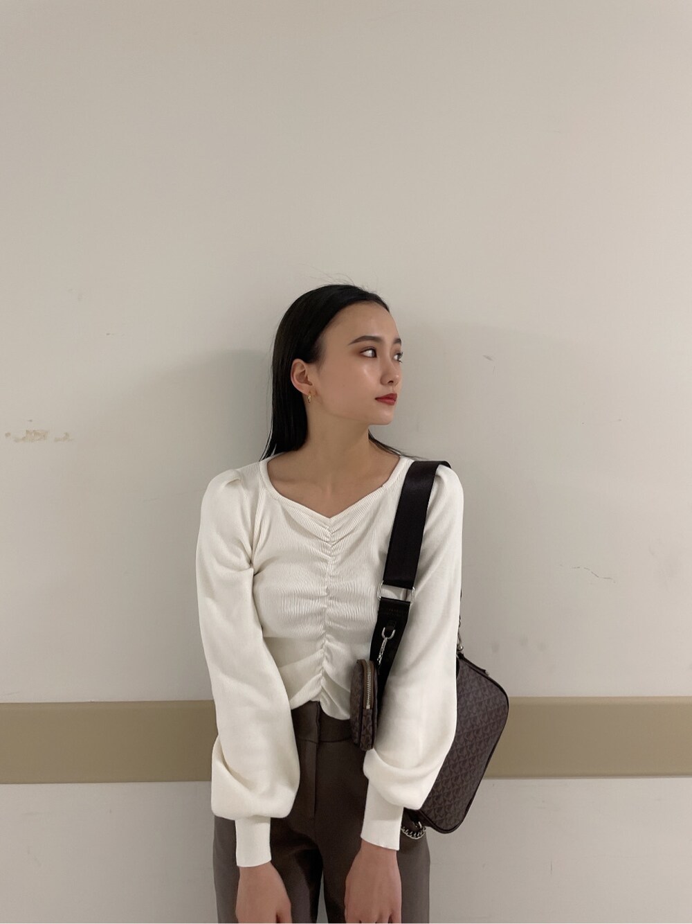 グレー系のその他パンツ、ホワイト系のニット/セーターを着用したレディースの冬コーディネートの3枚目の写真